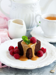 Sticky pudding with caramel sauce and fresh raspberries.