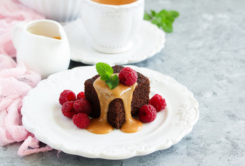 Sticky pudding with caramel sauce and fresh raspberries.