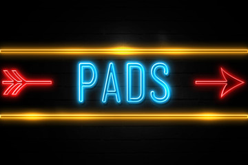 Pads  - fluorescent Neon Sign on brickwall Front view