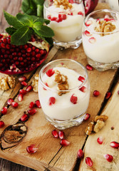yogurt dessert with walnuts and pomegranate selective focus
