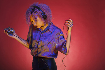 young afro american woman listening to music from her retro walkman - obrazy, fototapety, plakaty