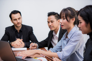 Business woman presenting work on laptop with her colleagues at meeting   