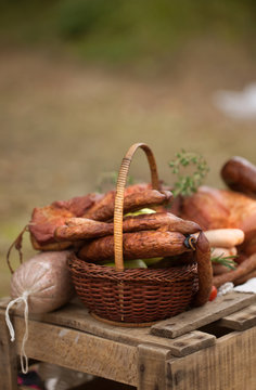 picnic - cured meat, sausages in a basket on the blanket