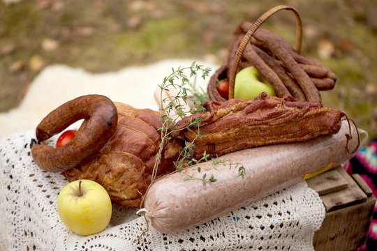picnic - cured meat, sausages in a basket on the blanket