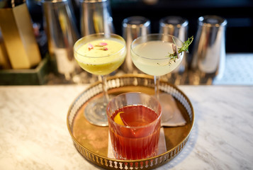 tray with glasses of cocktails at bar