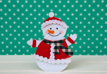 New year wallpaper snowman on green background with snowflakes. Christmas card idea.Space for text....