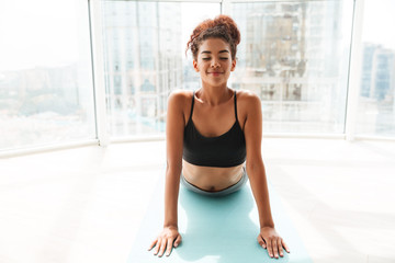 Young african woman making exercises at home