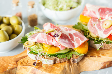 sandwich with ham, olives, rye bread and vegetables