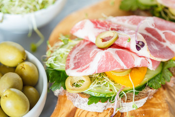 sandwich with ham, olives, rye bread and vegetables