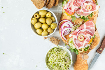 sandwich with ham, olives, rye bread and vegetables