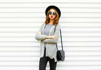 Fashion portrait woman with a black handbag on a white background