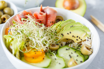 salmon poke with rice, avocado and sprouts.