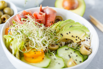 salmon poke with rice, avocado and sprouts.