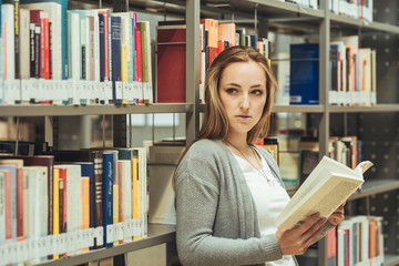 pretty female student learning in a high school library