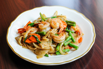 Pad Khee Mao, Stir-fried with wide rice noodles, hot peppers, carrots, green beans, onions, tomato and sweet basil leaves.