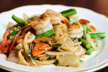 Pad Khee Mao, Stir-fried with wide rice noodles, hot peppers, carrots, green beans, onions, tomato and sweet basil leaves.