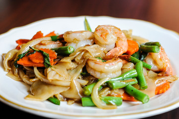 Pad Khee Mao, Stir-fried with wide rice noodles, hot peppers, carrots, green beans, onions, tomato and sweet basil leaves.