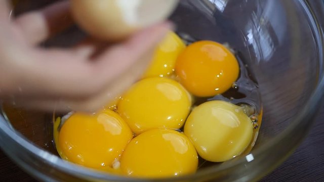 Egg being opened to put yolk in a mixing bowl