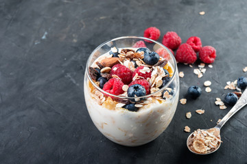 Natural yoghurt with fresh blueberry and raspberry on dark background