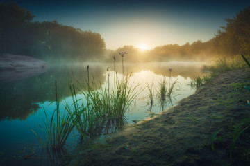 Morning fog on a river in a light of sunrise