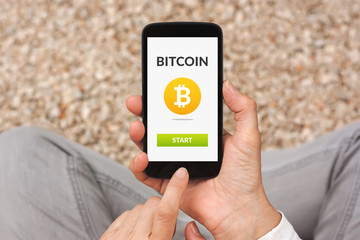 Hands holding smart phone with bitcoin concept on screen. All screen content is designed by me. Flat lay