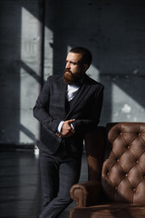 Bearded young businessman standing on modern loft office