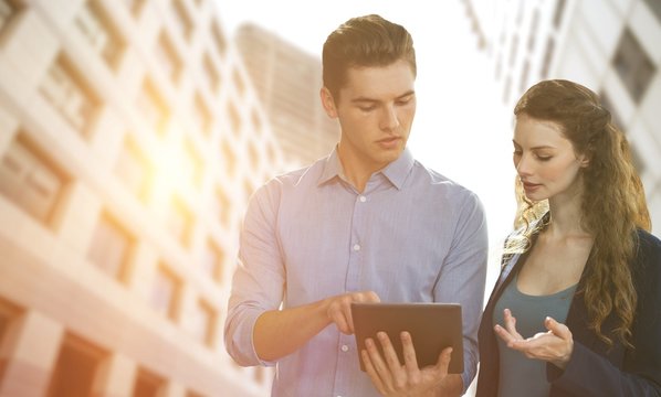 Composite image of concentrated business people using a digital