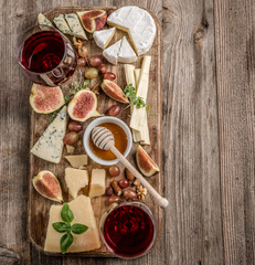 Cheese plate served with wine, nuts and honey 