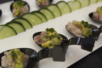 Tuna tartar with avocado served on a spoon.
