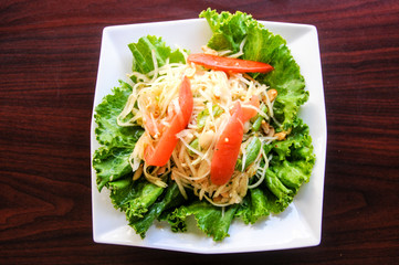 Papaya Salad, Shredded green papaya, tomatoes, green beans, crushed peanut & lime dressing.