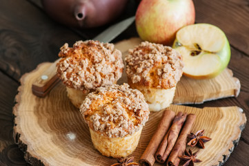 Apple cinnamon crumble muffins, spices and half of apples on a wooden board. Wooden background....