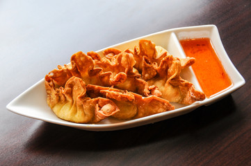 Crab Rangoon, Crispy dumplings filled with a mixture of crab, water chestnuts, celery & silky cream cheese, served with sweet & sour sauce.