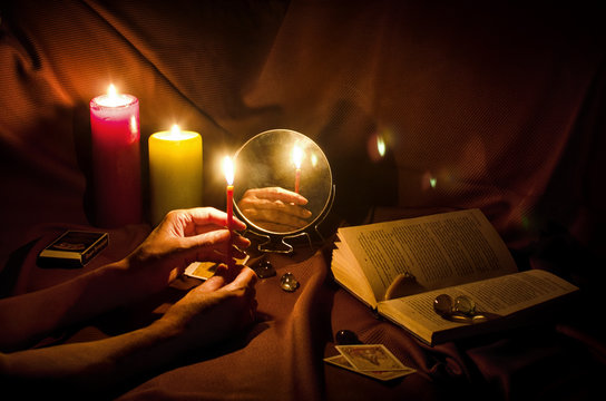 Fortune telling with a mirror and candles on a dark night
