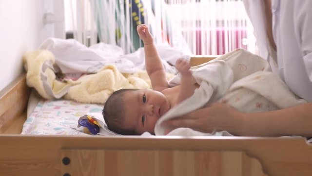 A nurse swaddles a newborn baby