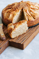 Easy apple tea cake on a wooden board. White stone background. Homemade baking.