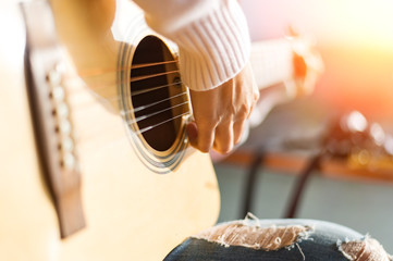 Music, close-up. Musician with a wooden guitar