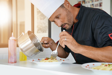 Chef in private kitchen preparing special pasta dish