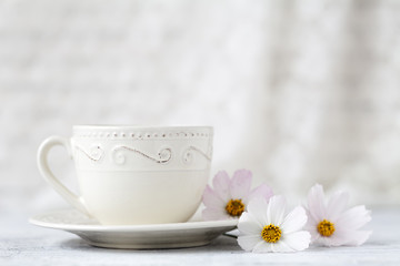 Obraz na płótnie Canvas cup of tea with flower on white