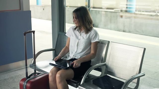 Young businesswoman finishing working on laptop and relaxing at railway station
