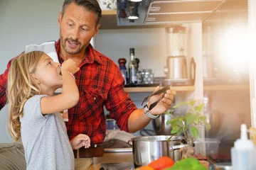 Crédence de cuisine en verre imprimé Cuisinier Papa avec sa fille cuisiner ensemble dans la cuisine à domicile