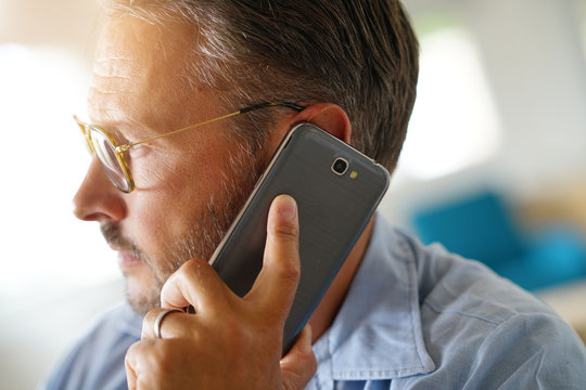 Closeup Of Mature Man Holding Smartphone To Ear