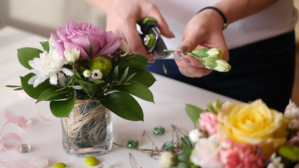 Beautiful young girl shows florist master class on making prekrassnogo bouquet of fresh flowers