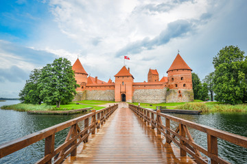 Trakai, Lithuania - August 15, 2017: Beautiful landscape of Trakai Island Castle, lake and wooden bridge, Lithuania. Trakai Island Castle and bright blue dramatic sky with clouds. 