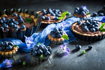 Homemade and rustic tarts made of chocolate cream and blueberries