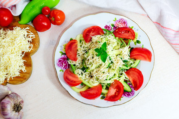 Homemade Zucchini Noodles Zoodles Pasta with Tomatos and Feta on white wooden background