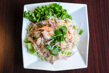 Yum Woonsen Glass Noodle Salad, Glass noodles salad served on a bed of lettuce with chicken and shrimp.