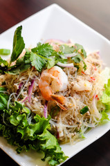 Yum Woonsen Glass Noodle Salad, Glass noodles salad served on a bed of lettuce with chicken and shrimp.
