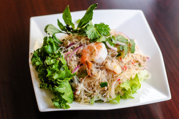 Yum Woonsen Glass Noodle Salad, Glass noodles salad served on a bed of lettuce with chicken and shrimp.