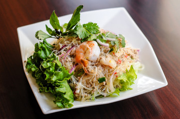 Yum Woonsen Glass Noodle Salad, Glass noodles salad served on a bed of lettuce with chicken and shrimp.