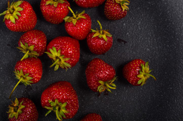 fresh ripe strawberries on black ceramic plate